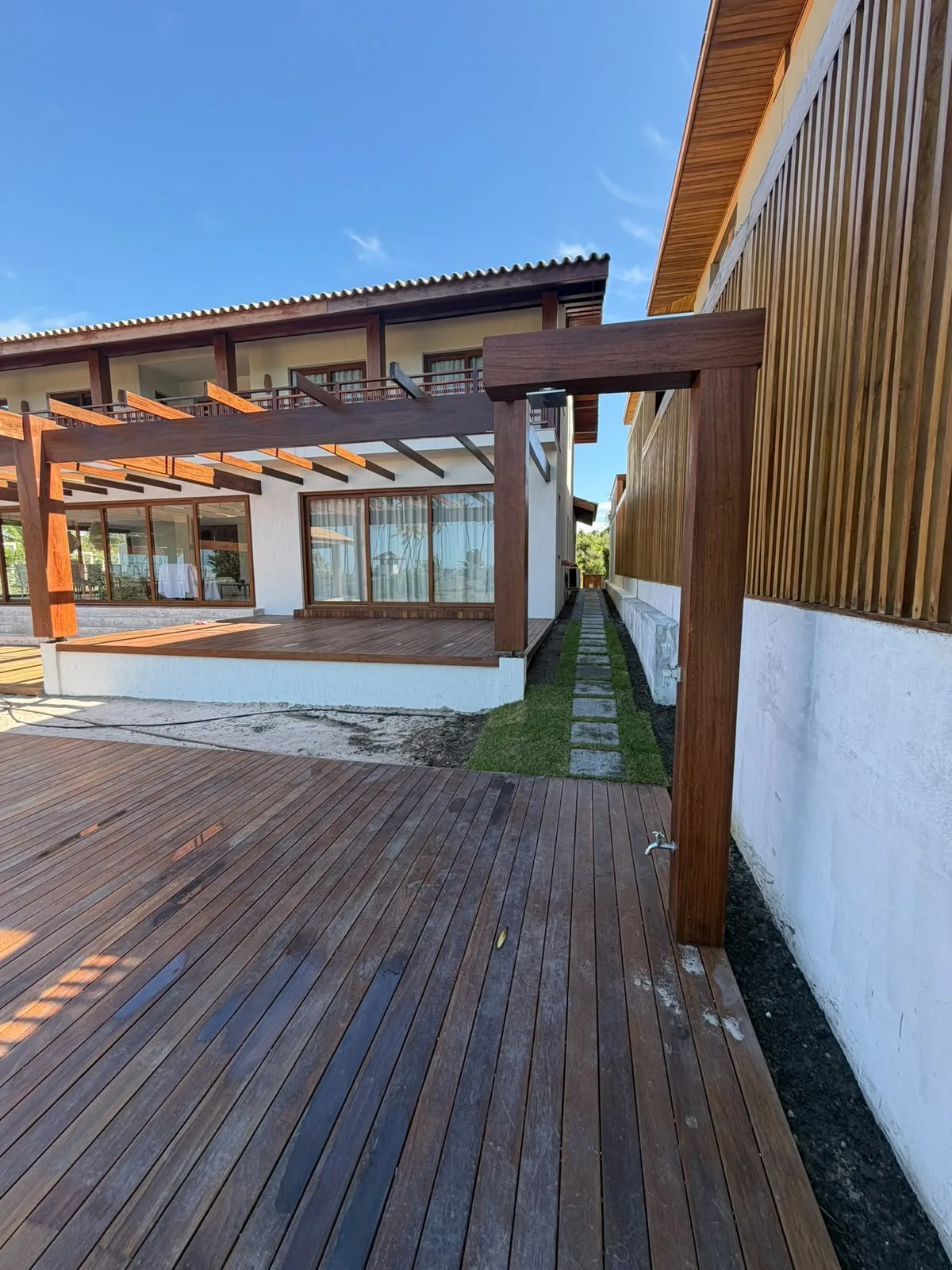Encontro do pergolado de madeira com a fachada da residência