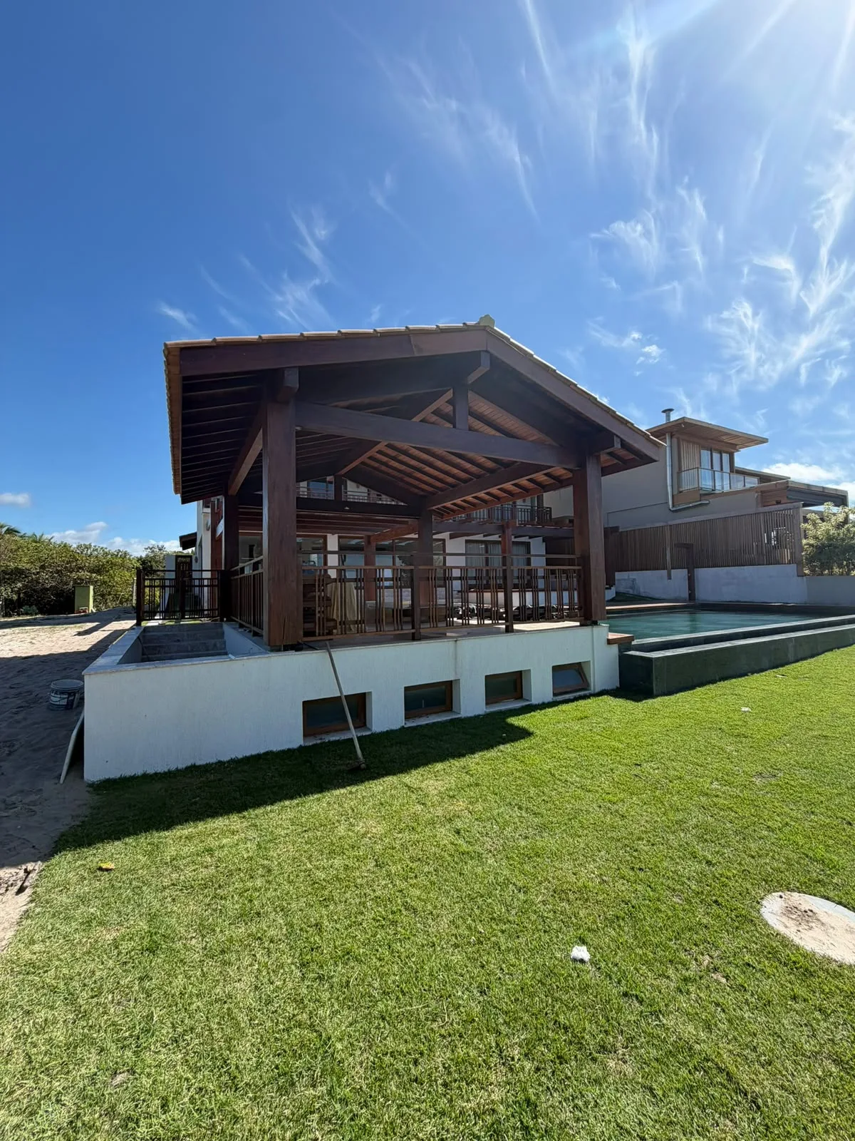 Pavilhão aberto com pilares, vigas e cobertura de madeira